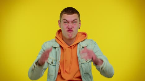 hombre adolescente gracioso haciendo expresiones faciales juguetonas y tontas y haciendo caras, haciendo tonterías mostrando la lengua