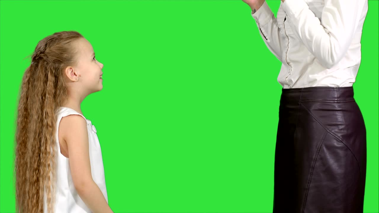 Little girl giving a gift to her mother and kissing on a Green Screen, Chroma Key