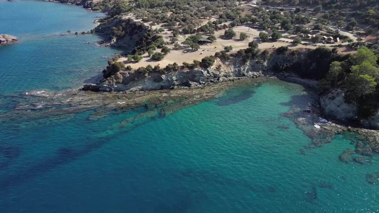 Tomas cinematográficas con dron aéreo que muestran la belleza agreste de la costa rocosa de Pafos en Chipre, donde las olas turquesas se encuentran con la impresionante orilla en una armonía espectacular.