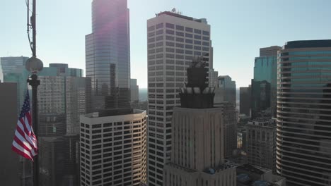 United-States-flag,-Downtown-Minneapolis-aerial-footage-in-the-background