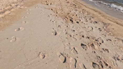 footprints along a sandy beach near ocean waves