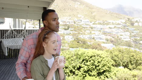 couple enjoying morning coffee on balcony with scenic mountain view, copy space