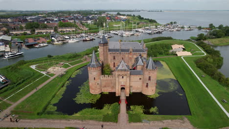 Castillo-De-Muiderslot:-Vista-Aérea-En-órbita-Sobre-El-Hermoso-Castillo-Y-Sus-Fosos,-Se-Puede-Ver-El-Puerto-Y-Los-Canales-Que-Lo-Rodean