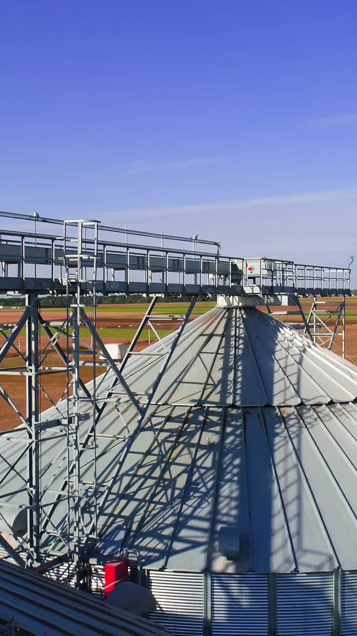 Aerial view. Metal grain elevator in agricultural zone. Grain warehouse Vertical video