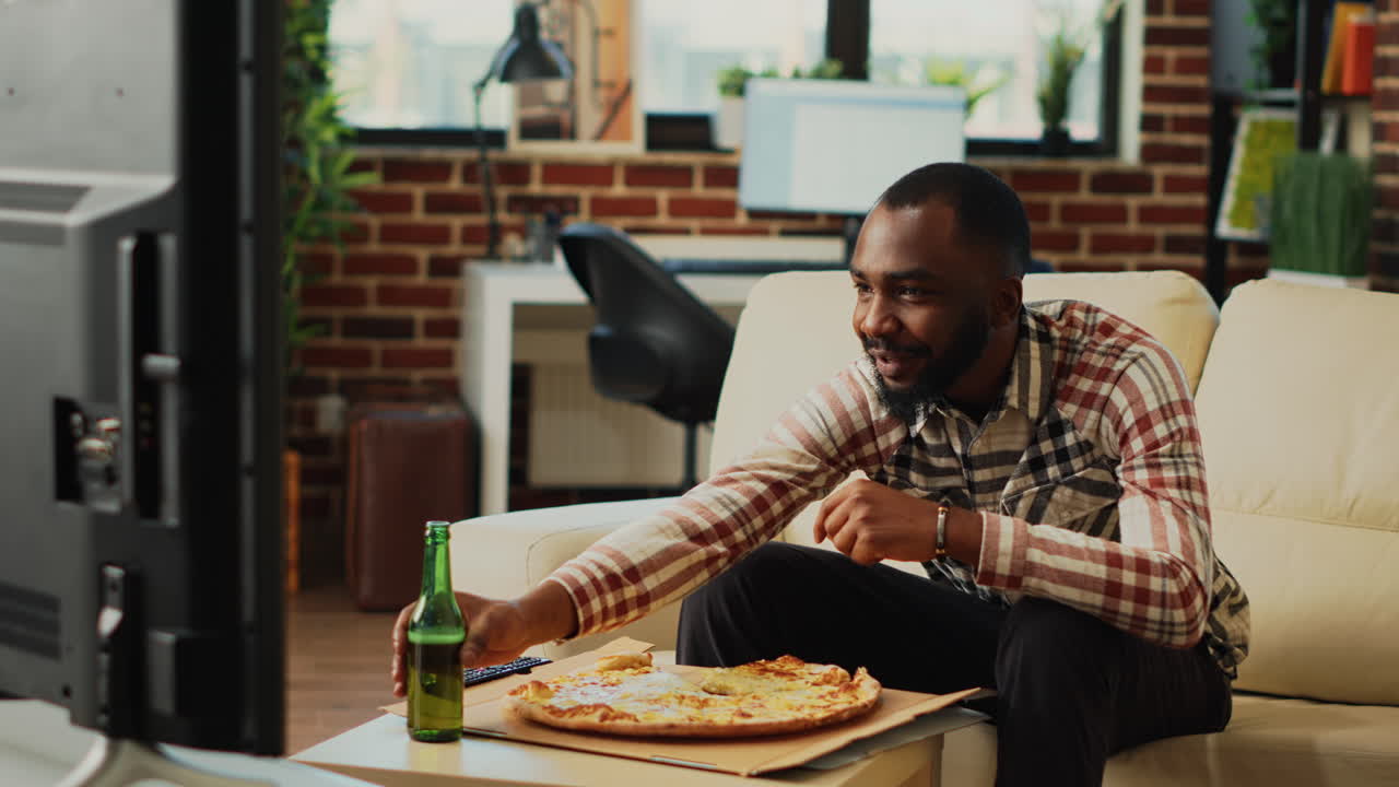 Smiling modern adult eating slice of pizza from delivery