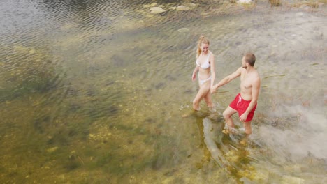 caucasian couple having a good time on a trip to the mountains, wearing bathing suits and walking in