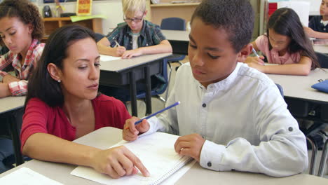 teacher helps schoolboy in class, close up, shot on r3d