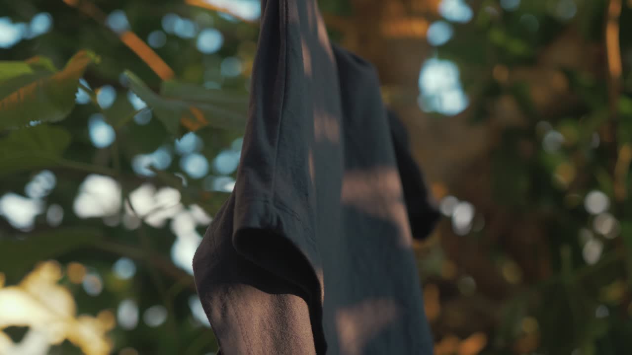 햇빛이 비치는 산들바람에 걸려 있는 티셔츠 건조