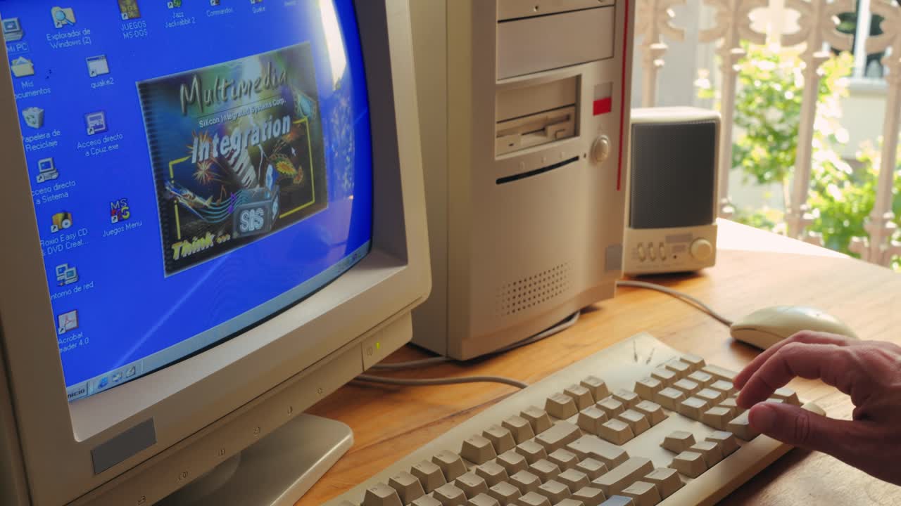 BARCELONA, SPAIN, 10 JUNE 2025. Man working and gaming on retro computer PC, IT engineer with vintage computer at home, using old fashion technology, close up of retro setup.