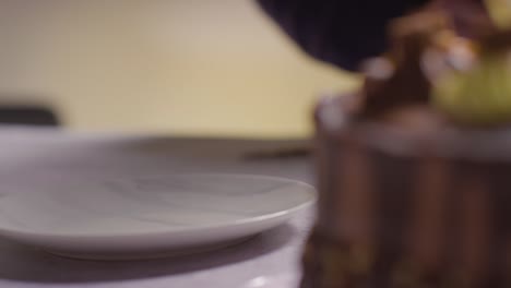 Close-Up-Shot-Of-Person-At-Home-Cutting-Slice-From-Chocolate-Celebration-Cake-On-Table-4