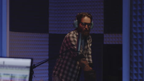 man in recording studio with microphone and bubble wrap