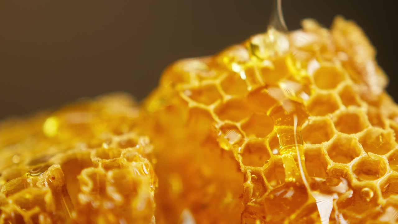 Miele dorato che cola su celle naturali del favo