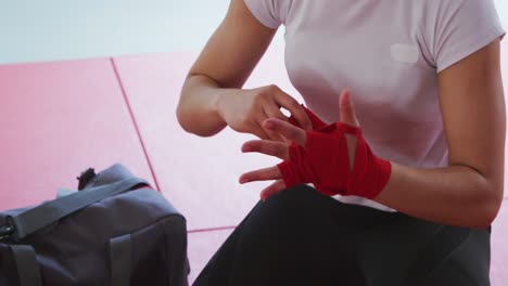 mujer caucásica poniendo correa alrededor de sus muñecas