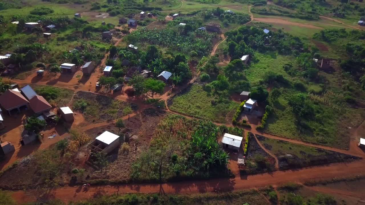 Motorcycle Driving On A Dusty Street In Uganda, Africa - Drone Shot