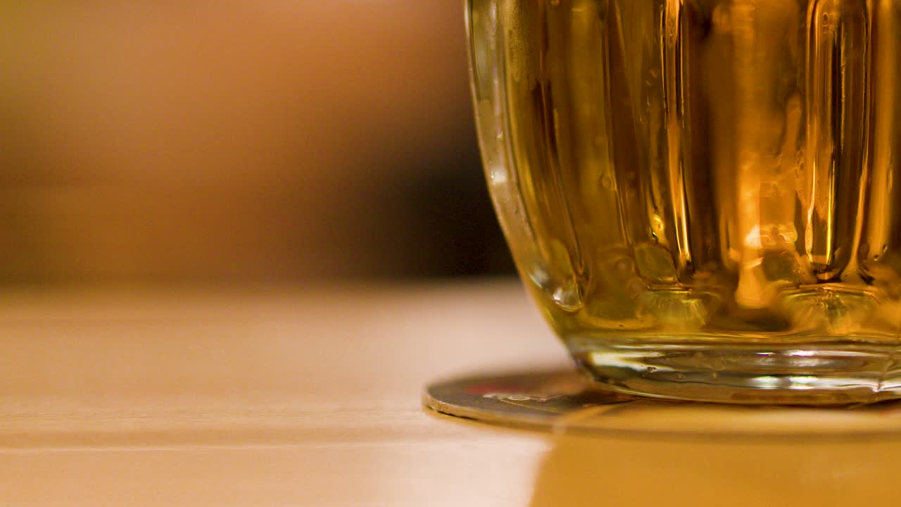 A traditional lager is poured into a glass mug, forming foam at a brewery table