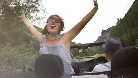 4k footage of a woman knelt in the convertible and screaming of joy