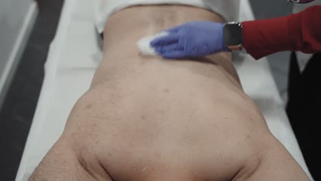 el afeitamiento de la espalda de un hombre para la depilación láser