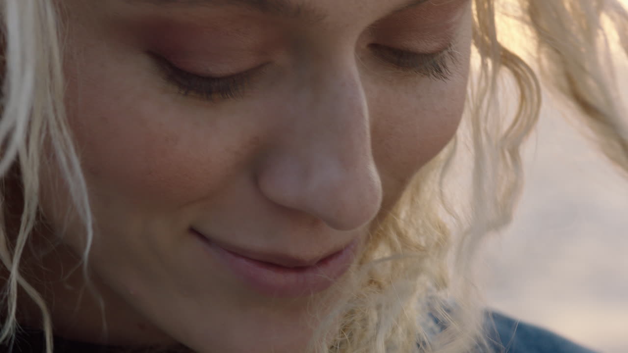 retrato en primer plano de una hermosa mujer rubia que parece segura disfrutando de un estilo de vida de vacaciones relajado sintiendo libertad en la orilla del mar al atardecer