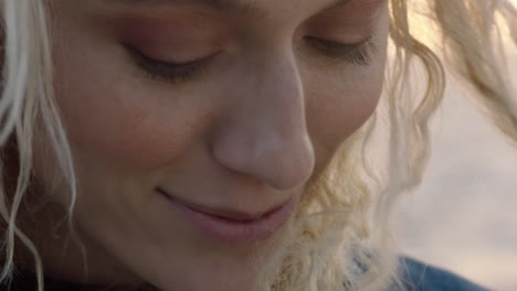 close up portrait of beautiful blonde woman looking confident enjoying relaxed vacation lifestyle feeling freedom on seaside at sunset