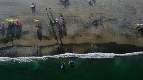 Drone-footage-spinning-and-going-down-by-the-water-line-on-a-beach-in-Spain