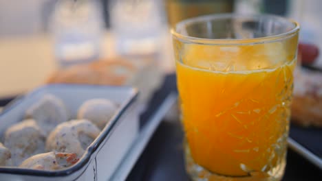 cooked meatballs in truffle sauce and a glass of fresh orange juice served on the table