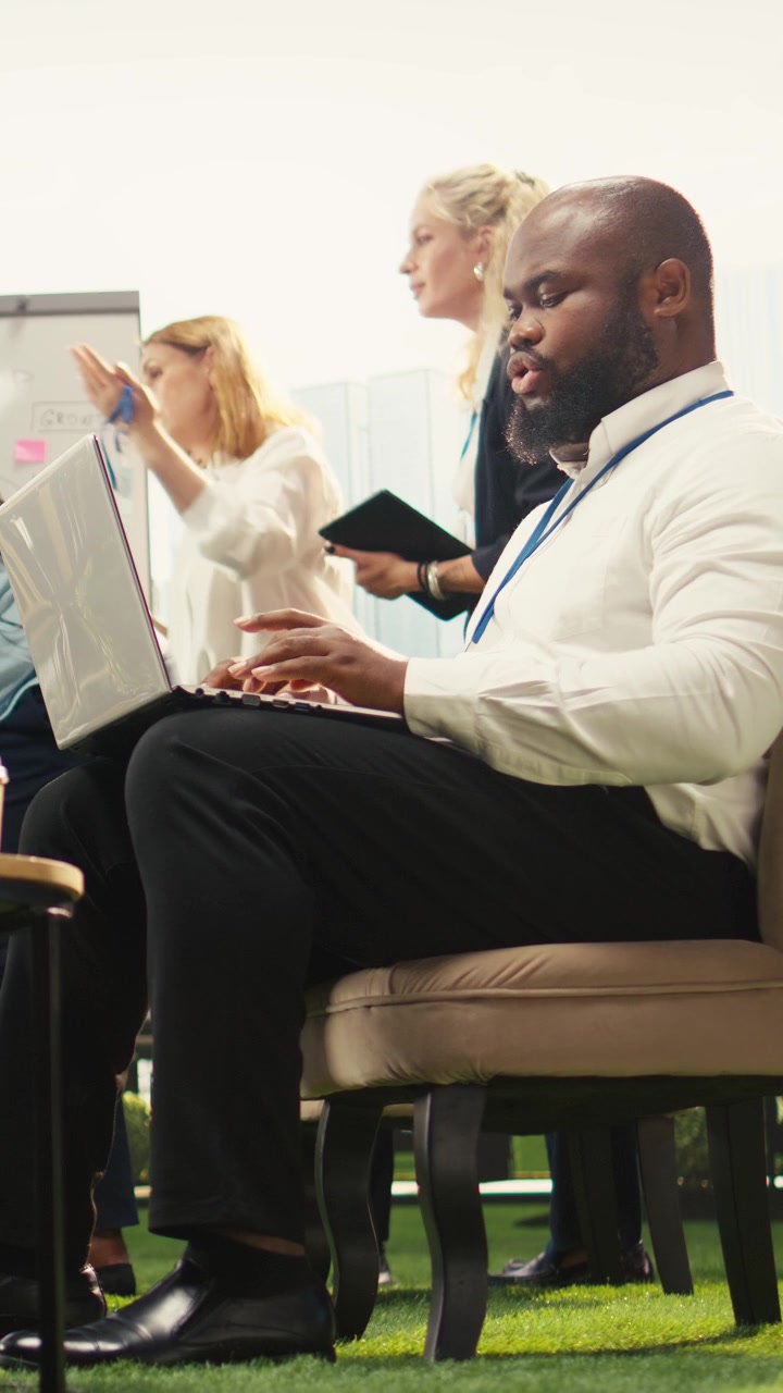 Video verticale. Professionista d'azienda afroamericano che lavora con il laptop su nuove idee
