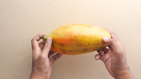 uomini che tengono una papaya sul tavolo