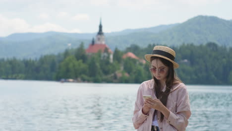 woman using a phone by the lake