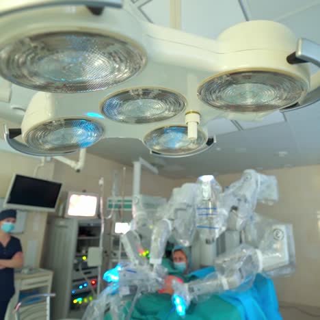 surgical lamps off during robotic surgery. modern medical equipment in clinic. group of doctors observe the robotic surgery on screen in the operating room