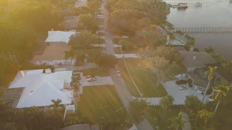 aerial view of red sports car driving through south florida street at sunset with river on right