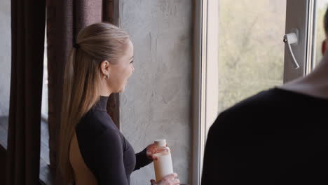 elegant woman in black open-back dress interacting indoors