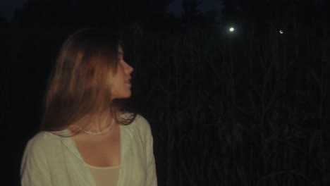 woman in a cornfield at night