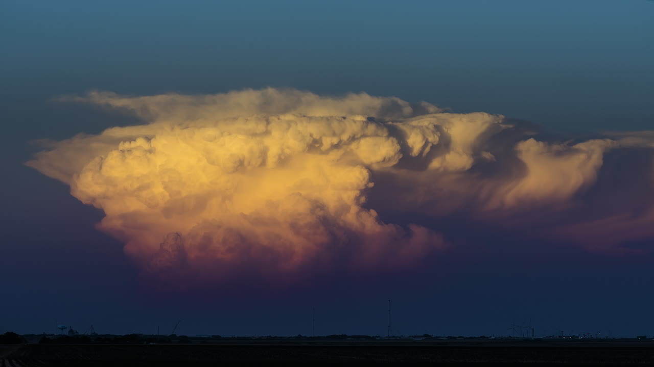 Drifting storm clouds reflect vibrant sunset colors