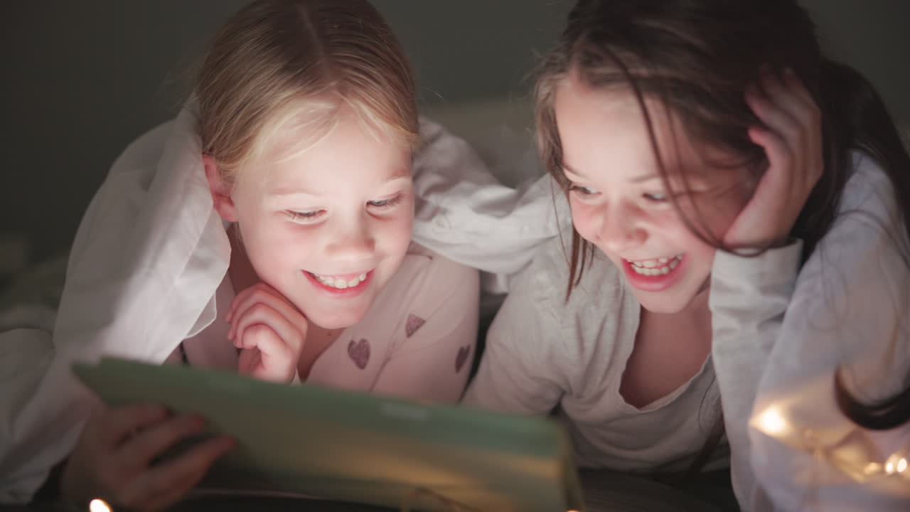 noche, cama y chicas con una tableta
