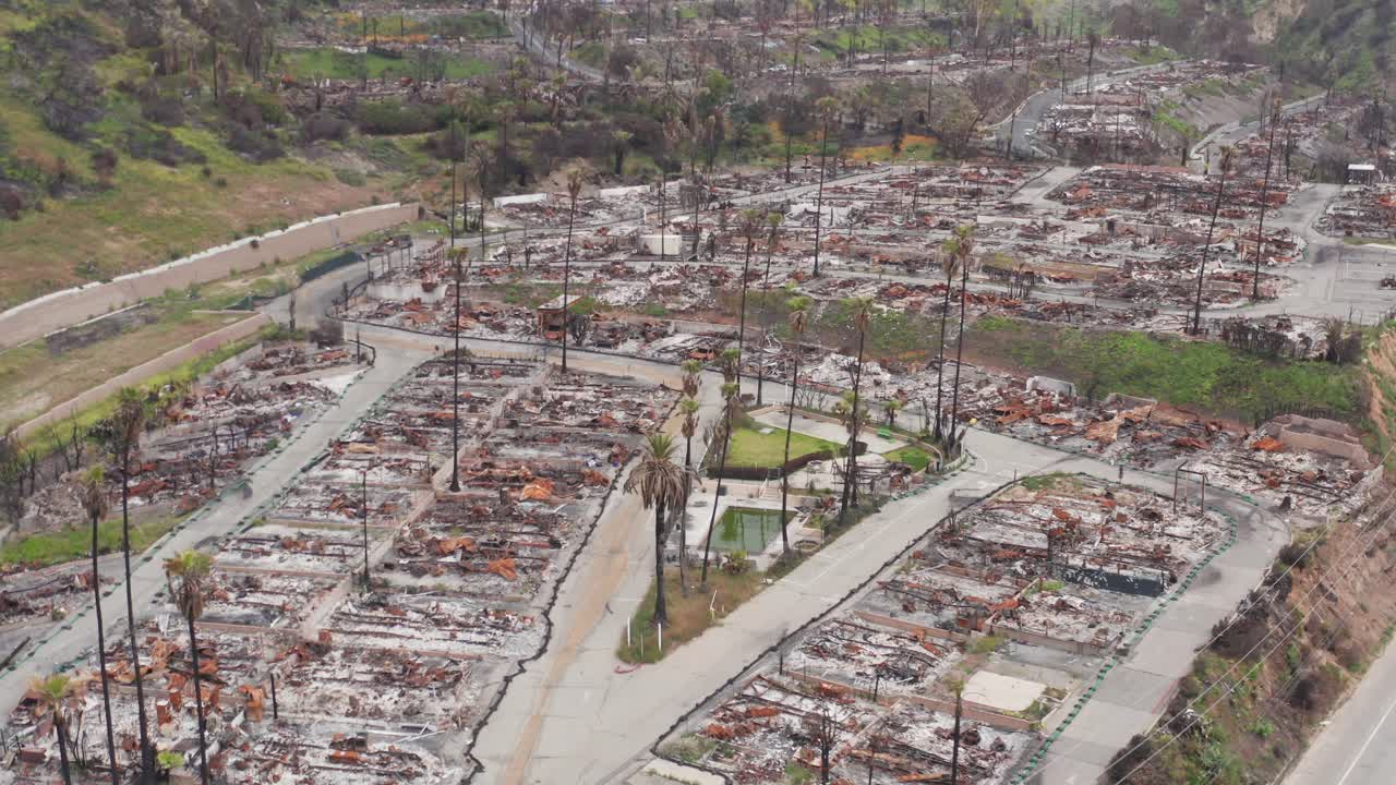Aerial descending flyover shot of homes damaged by the Palisades Fire in the Tahitian Terrace neighborhood of Pacific Palisades, California. 4K