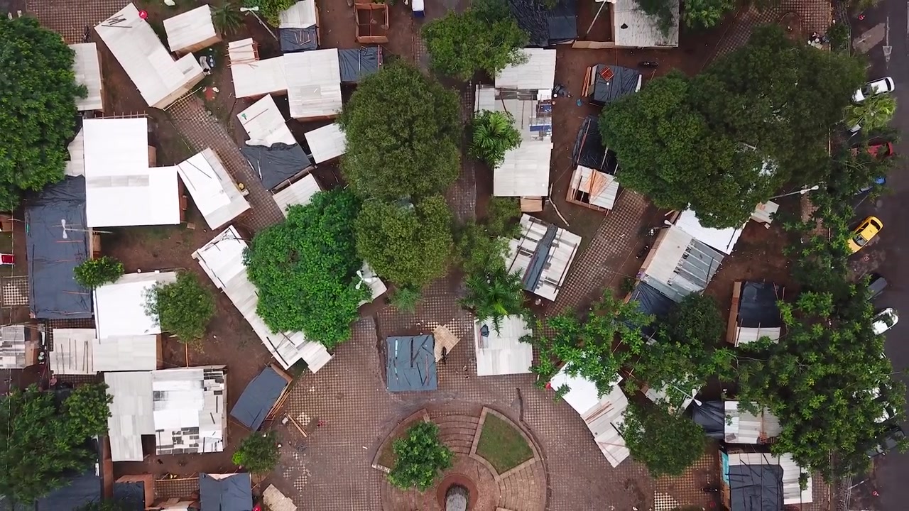Série de quatro fotos de uma área de favela com barracos e árvores.