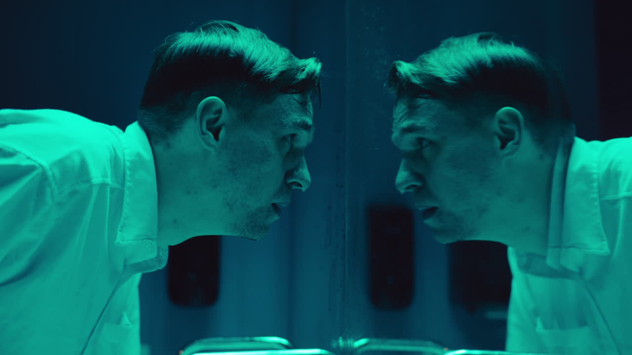 Distressed Man Washing Face in Front of Mirror at Night