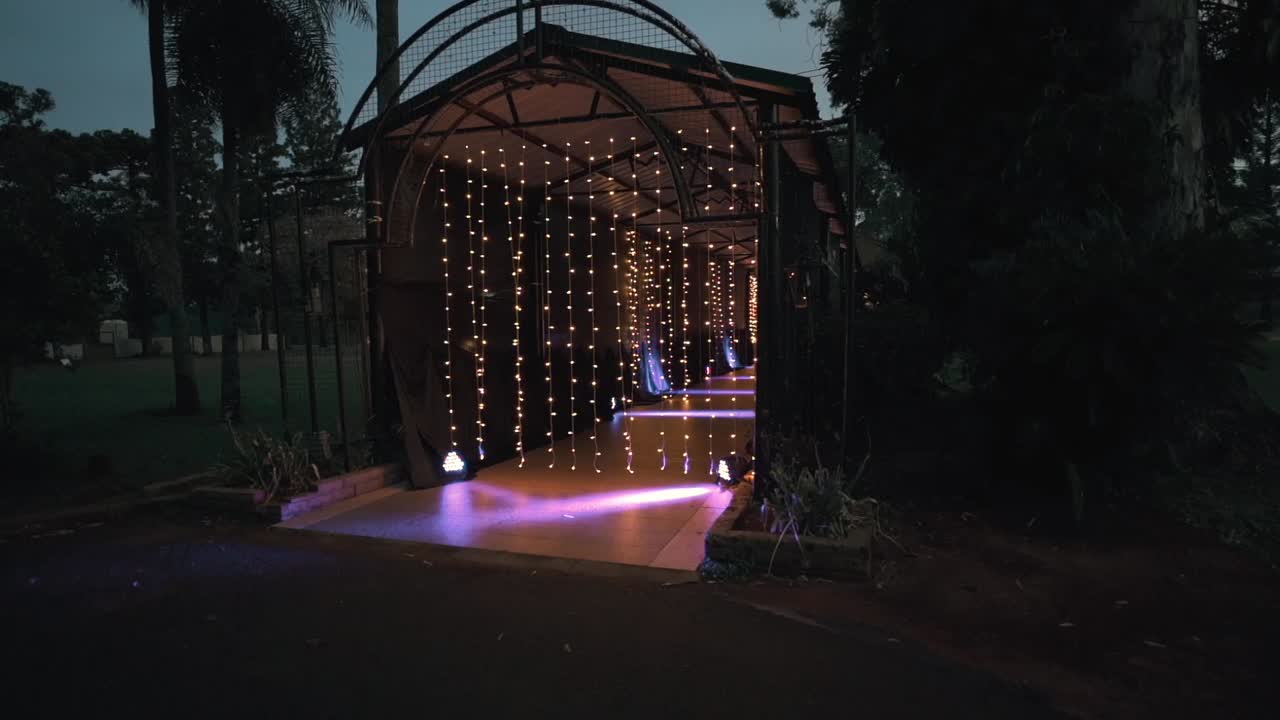 Warm Curtain String Lights Illuminated Covered Walkway In A Luxury Event. Sideways Shot