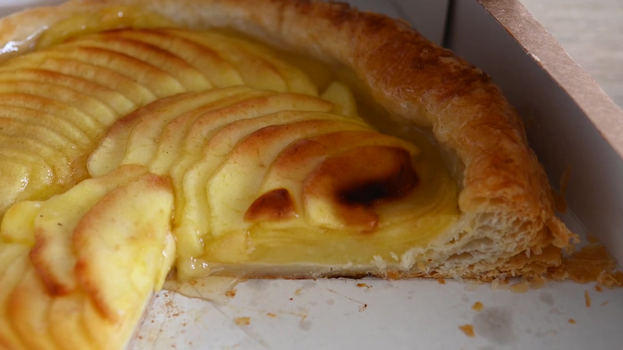 Apertura di una scatola di cartone contenente una crostata di mele fresca