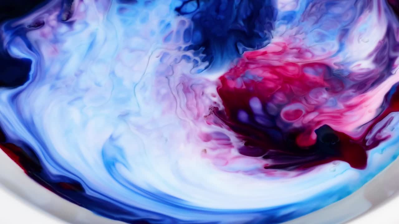 Watch vibrant blue and red colors swirl and blend dynamically in a captivating milk experiment.
