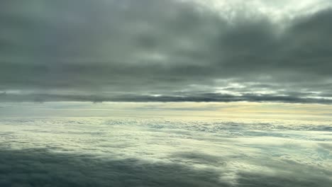 aerian view from a cockpit flying between cloud layers in the sunset , white and gray clouds