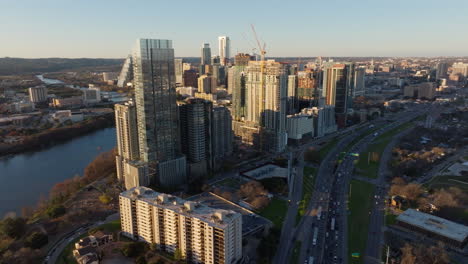 Aerial-establishing-Shot-Capturing-Cosmopolitan-City-District-in-Austin-Texas,-Bustling-Traffic,-and-Cars-in-Motion-on-the-Highway