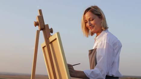 woman painting outdoors on an easel