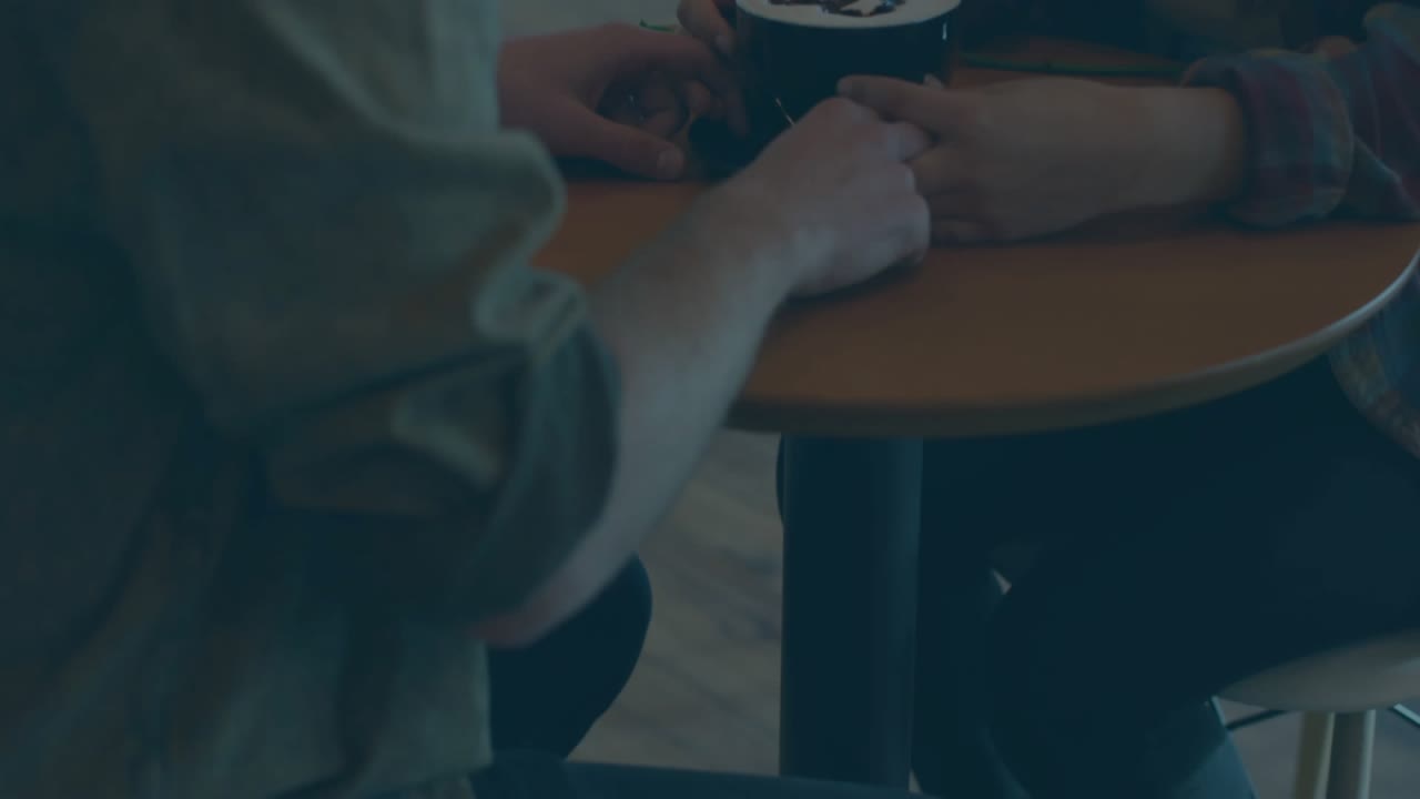 Couple holding coffee cup in cafe creating code overlay with blue progress bars for tech discussion