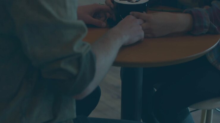 Couple holding coffee cup in cafe creating code overlay with blue progress bars for tech discussion