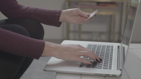 captura de pantalla en cámara lenta de una joven que usa una computadora portátil para hacer una compra en línea, celebra con un golpe de puño cuando completa la compra, sin calificar