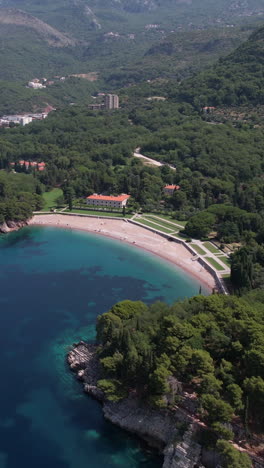 vertical drone shot of king's beach and royal villa in milocer park, montenegro