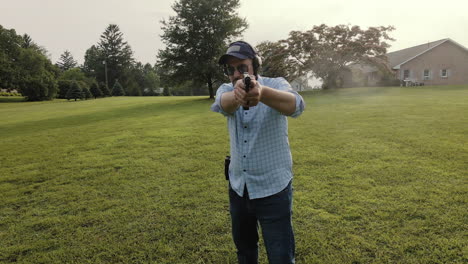 hombre disparando pistola hacia la cámara