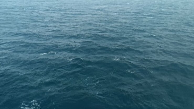 Vista da una nave che naviga sull'oceano blu profondo.