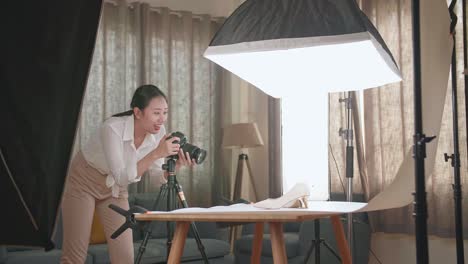 asian female photographer taking photos of women's shoes in home studio